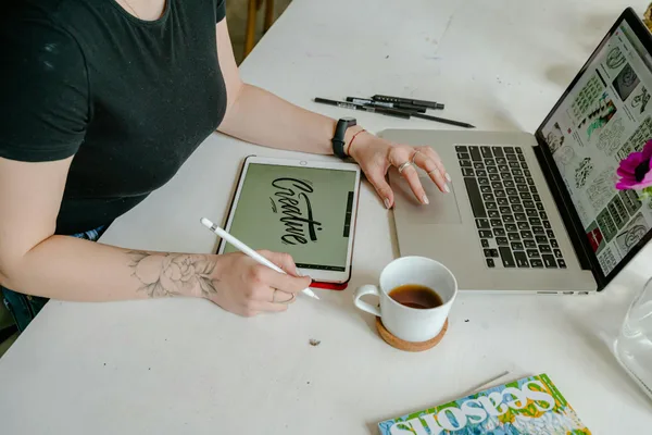 크리에이티브 오피스에서 태블릿과 노트북으로 디자인 작업하는 여성