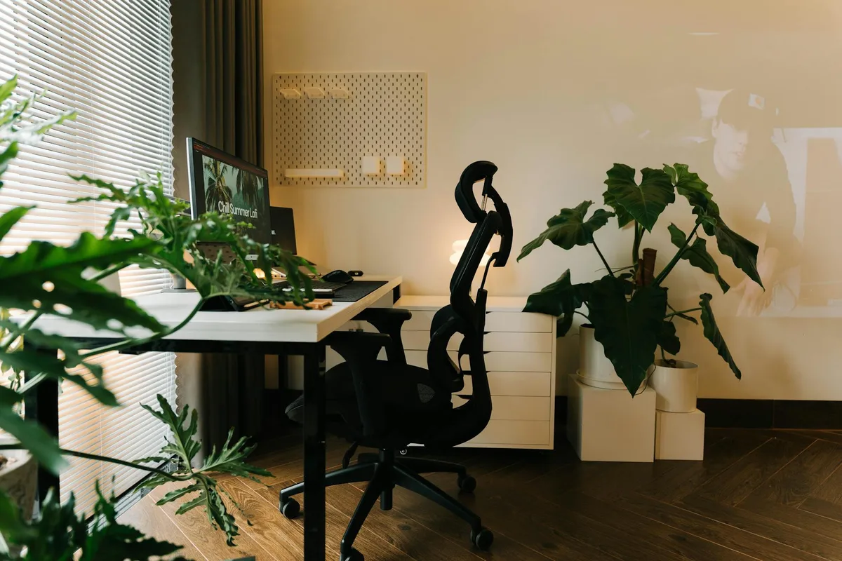 Stilvolles Homeoffice-Setup mit Pflanzen und ergonomischem Stuhl für produktives Arbeiten
