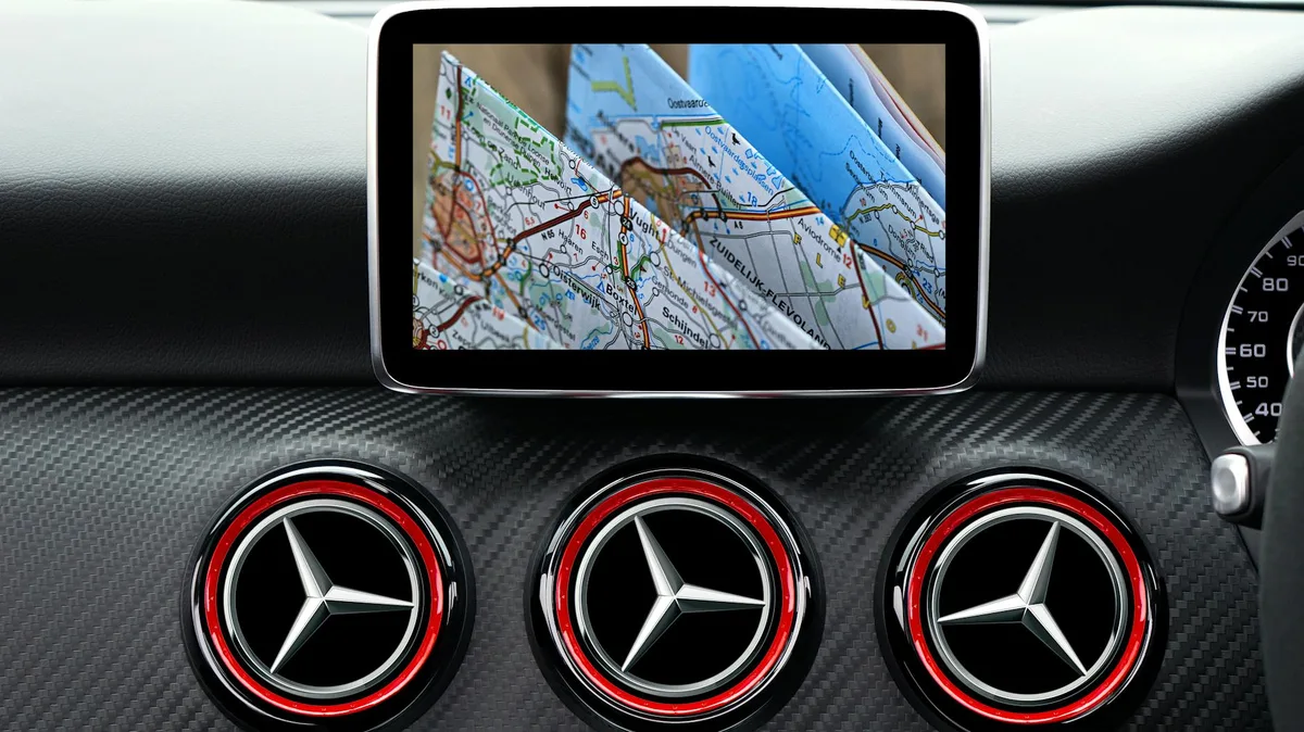 Primo piano cruscotto auto lusso con navigatore GPS e mappa stradale