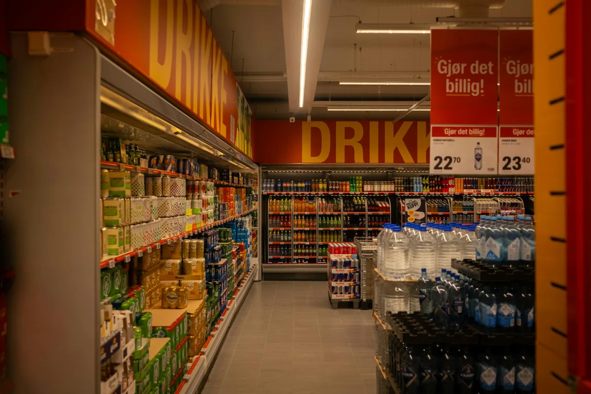 Corredor de bebidas colorido em supermercado com sinalização promovendo ofertas.