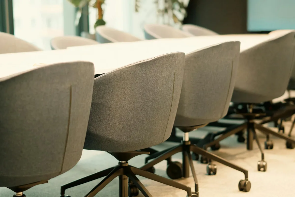 Salle de conférence contemporaine avec rangée de chaises vides et lumière naturelle douce