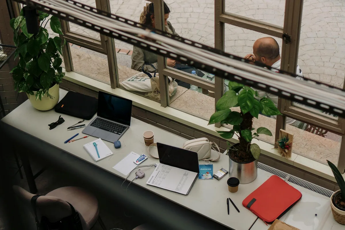 Spazio di lavoro indoor accogliente con laptop e piante, perfetto per ispirare il lavoro da remoto