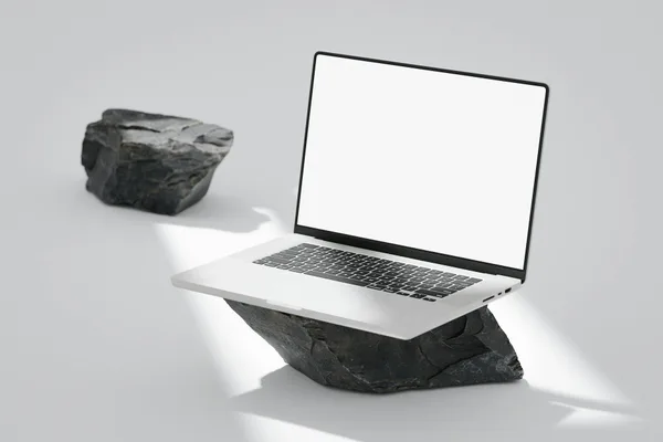 Laptop elegante su rocce in ambientazione minimalista