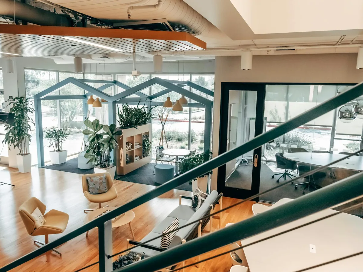 Escritório aberto moderno com plantas verdes e luz natural