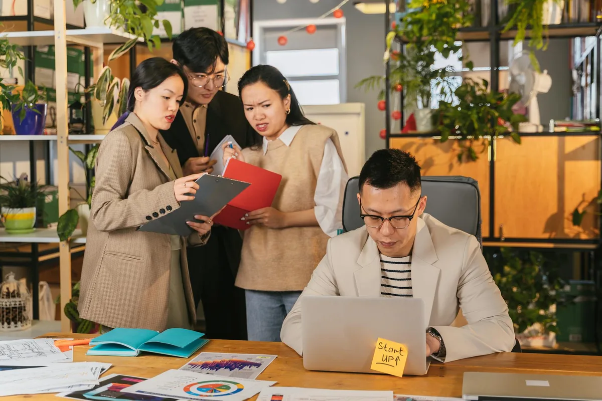 Gruppo di colleghi in riunione in un ufficio vivace e pieno di piante