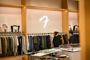 Interior of a stylish clothing store in Tokyo featuring two shoppers browsing modern apparel.