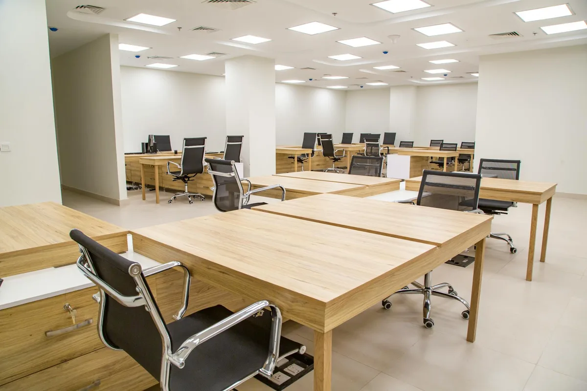 Großzügiges modernes Büro mit Holztischen und ergonomischen Stühlen, ideal für Produktivität