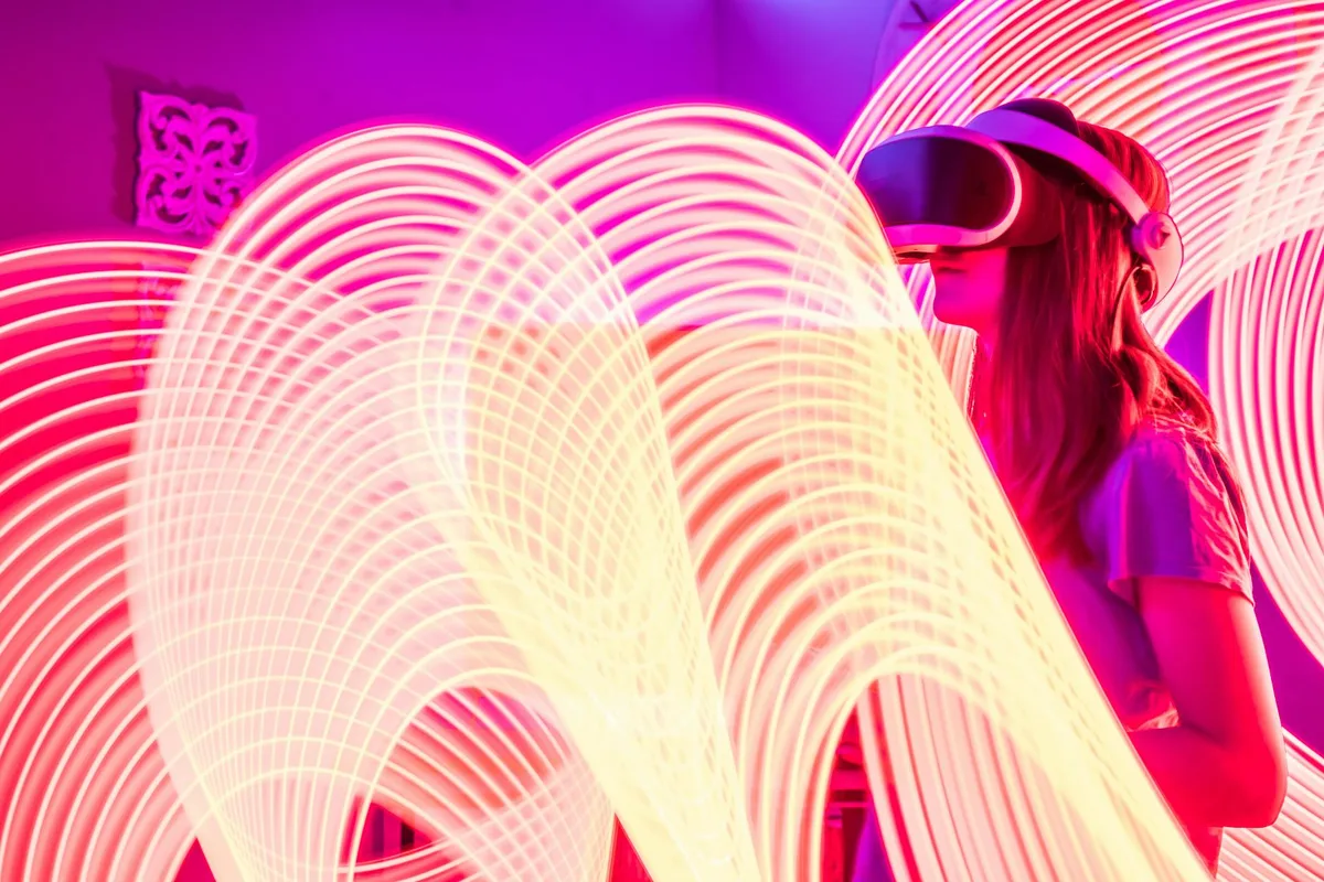 Mujer con gafas VR y estelas de luz neón en experiencia futurista