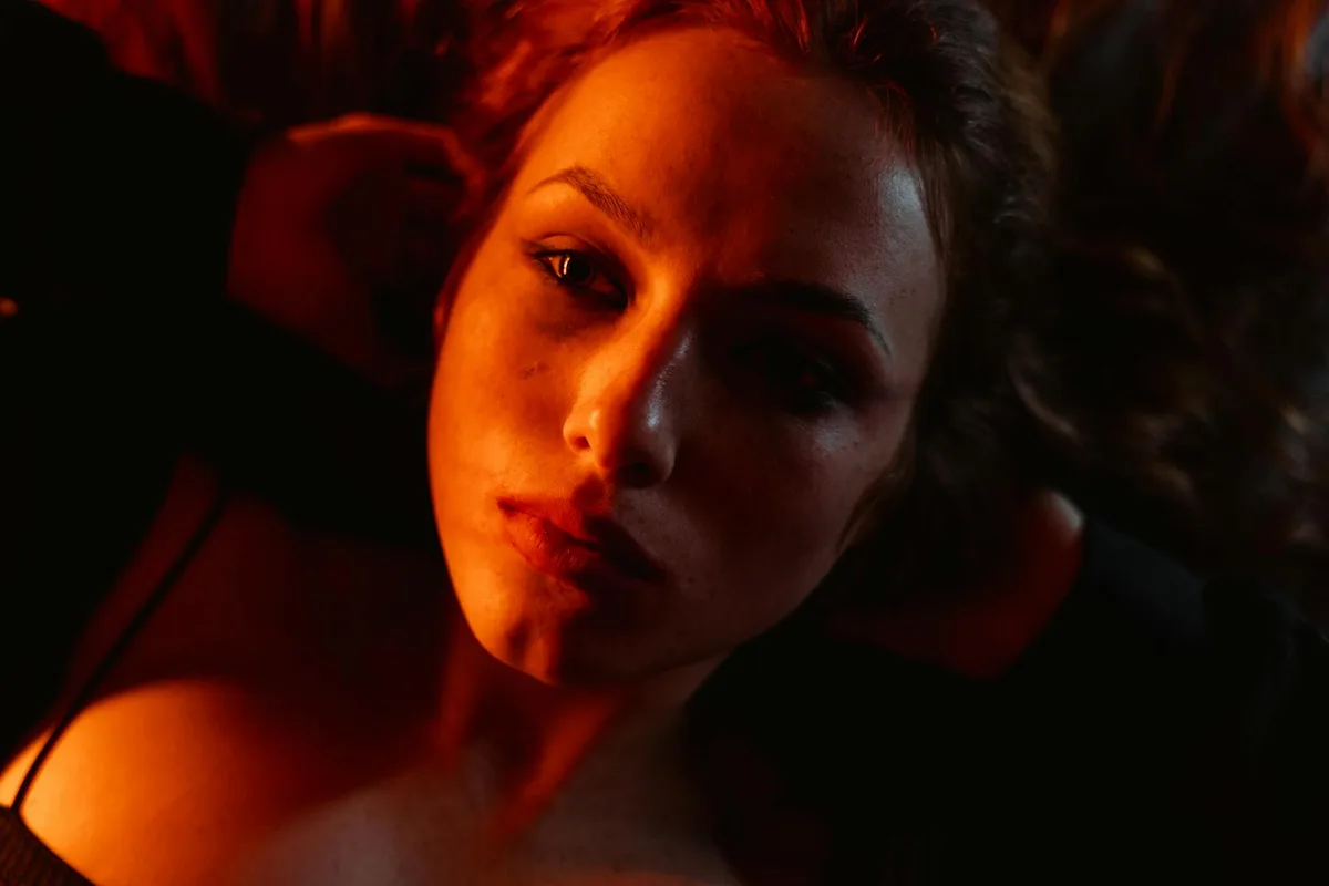 Nahaufnahme-Porträt einer jungen Frau unter roter Beleuchtung