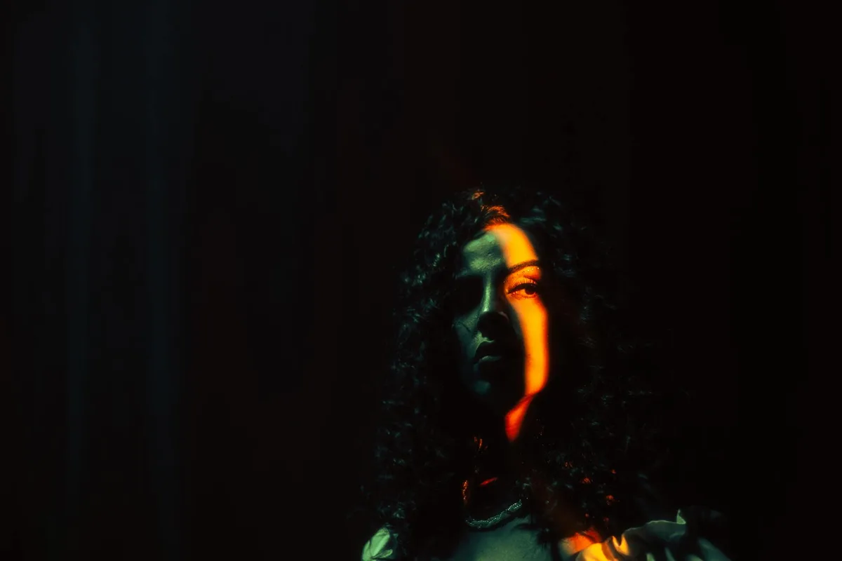 Ritratto di donna con luce drammatica e ombre misteriose