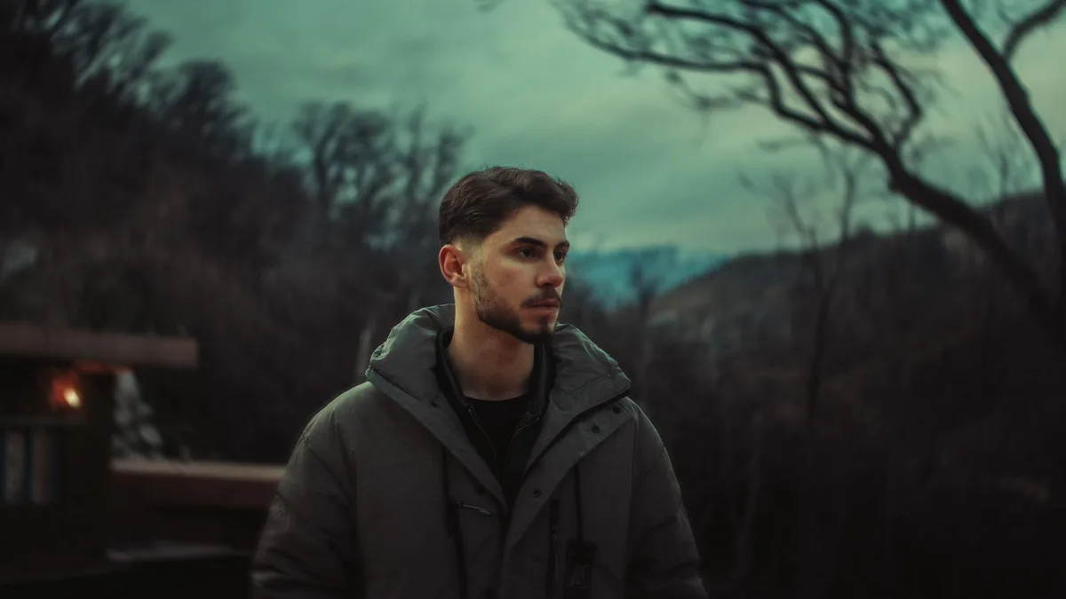 Ritratto drammatico di uomo in cappotto invernale in paesaggio curdo malinconico