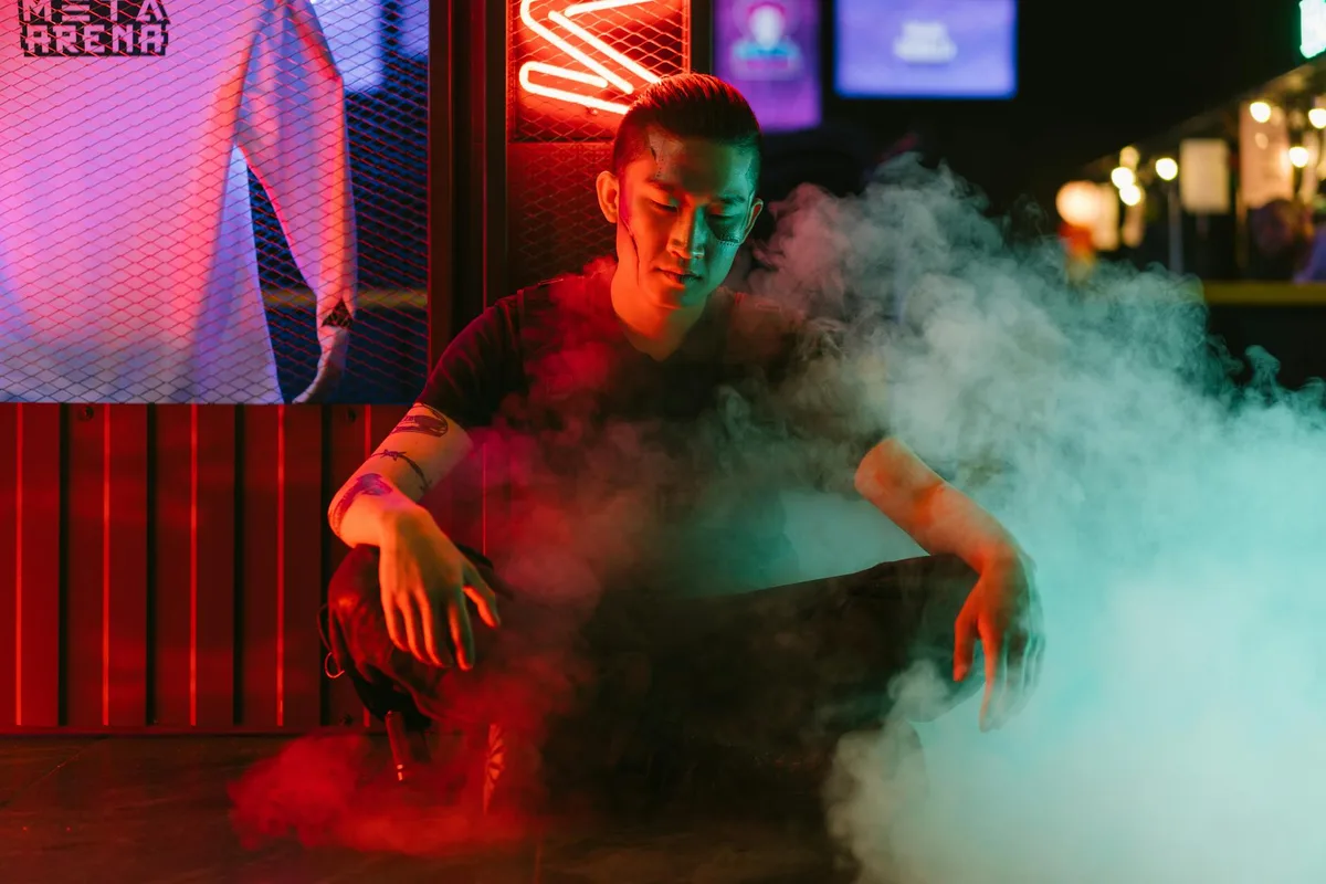 Sitzender Mann im Cyberpunk-Setting mit Neonlichtern und Rauch.