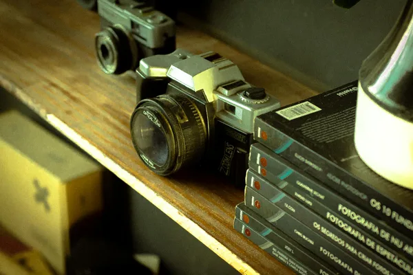 Retro-Kamera auf Holzregal mit Fotobüchern, die Nostalgie hervorruft