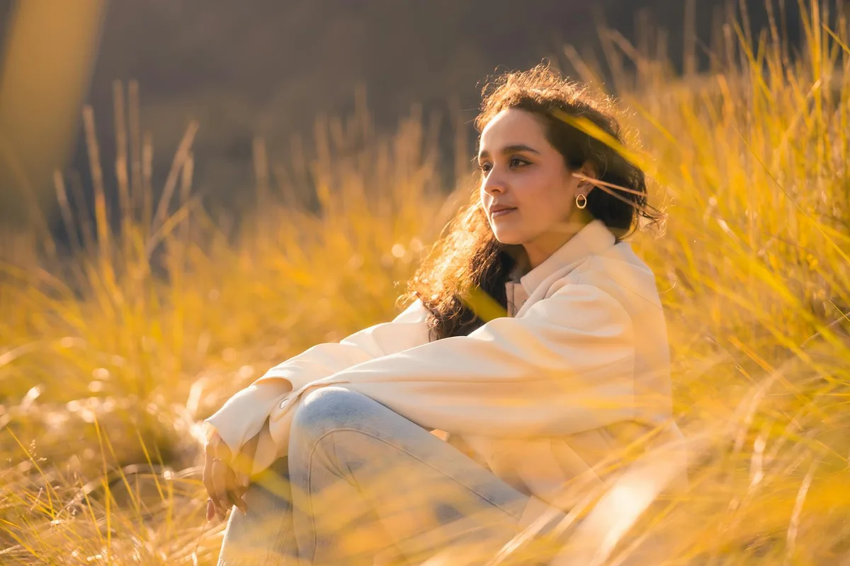 Femme profitant de la beauté sereine d'un champ ensoleillé à l'heure dorée