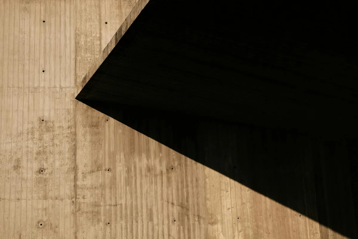 Muro di cemento astratto con ombre contrastanti e design geometrico