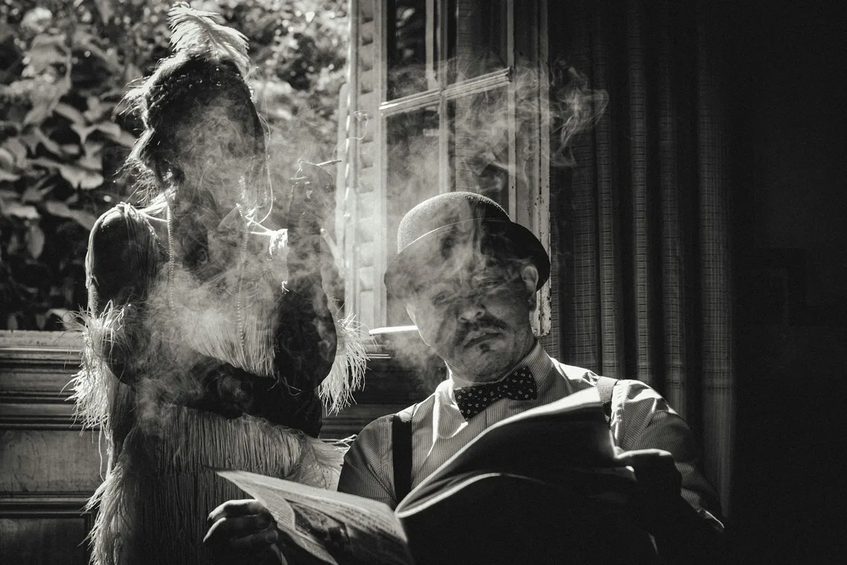 Image noir et blanc d’un couple vintage : robe garçonne et chapeau melon, élégance intemporelle