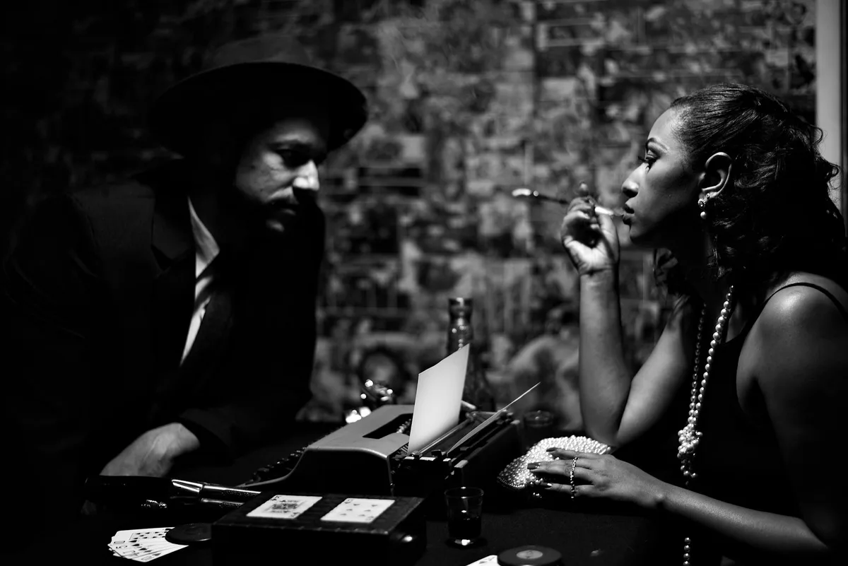 Foto retrò in bianco e nero di coppia che fuma in interni con macchina da scrivere