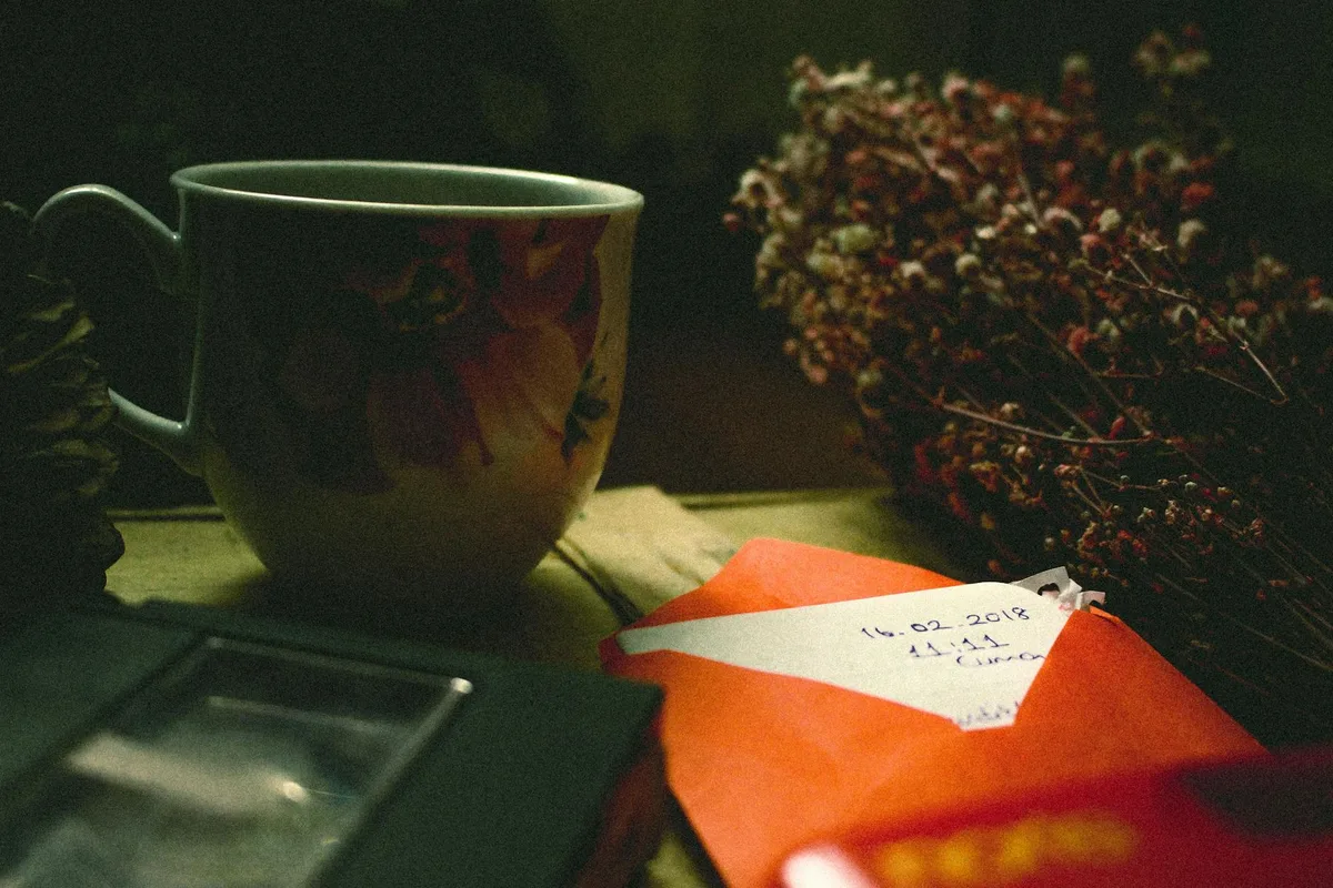 Tazza in ceramica con fiore, lettera e videocassetta