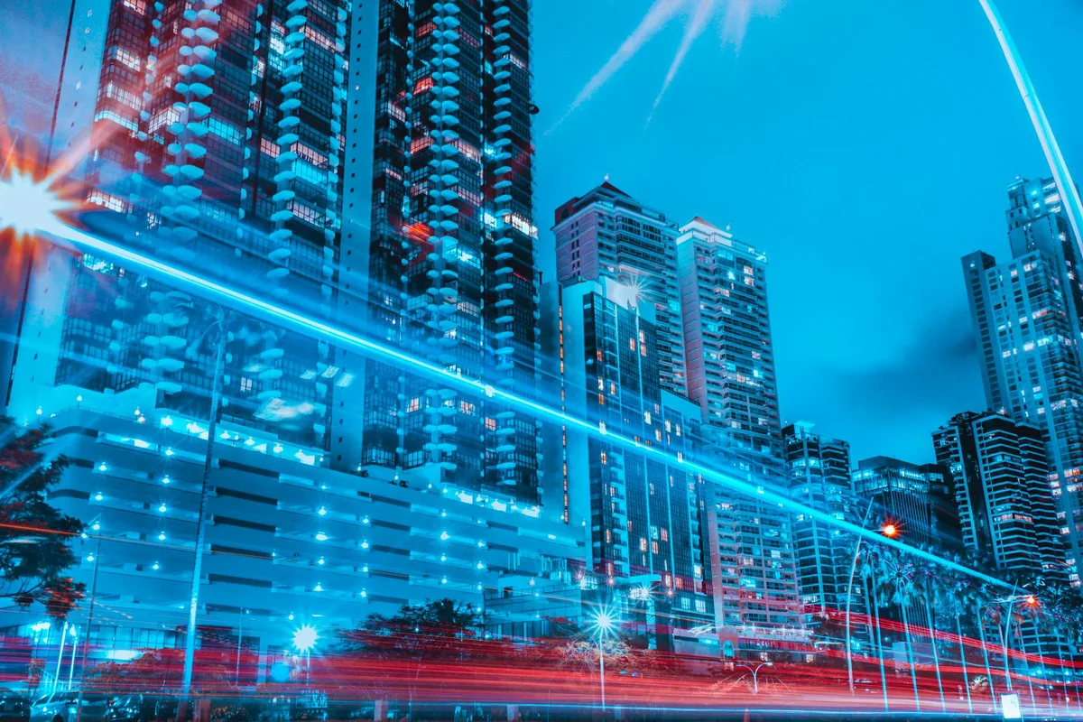 Paysage urbain coloré de gratte-ciel illuminés et de traînées lumineuses la nuit