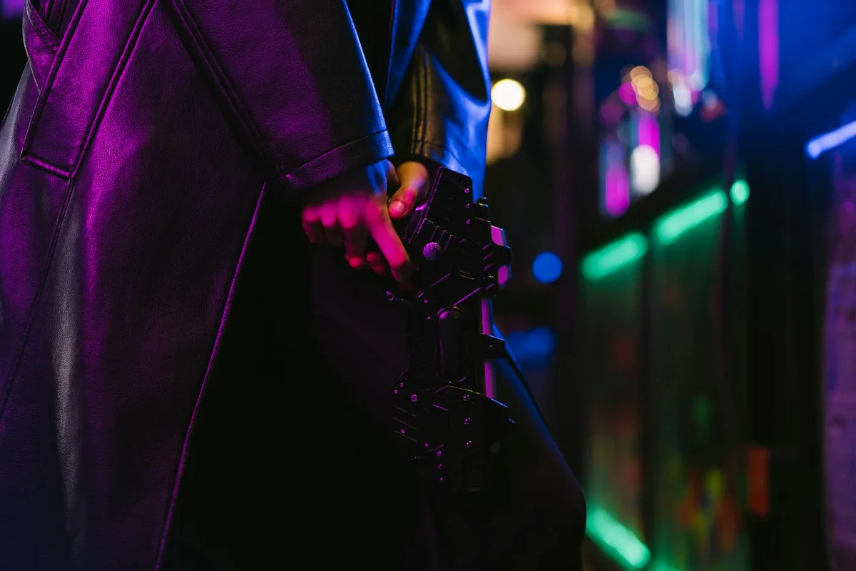 Dunkles Cyberpunk-Bild einer futuristischen Person mit Waffe im Neonlicht
