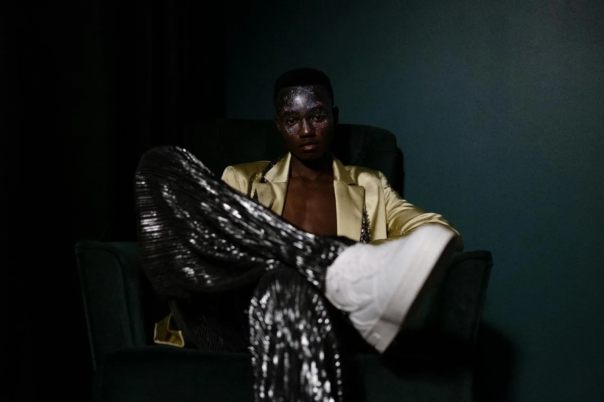 Studio-Porträt eines Mannes mit kreativem Make-up und stilvoller Kleidung