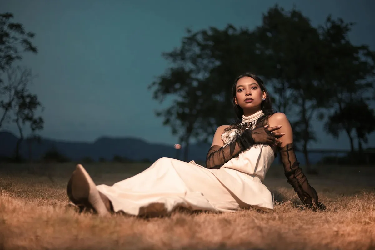 Femme en robe blanche posant au crépuscule, mode élégante