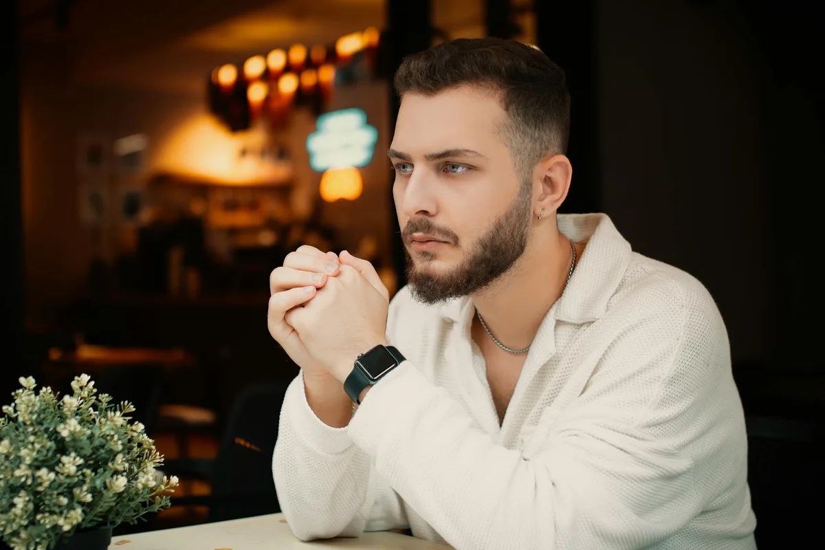Nachdenklicher Mann an einem Café-Tisch mit modernem Stil