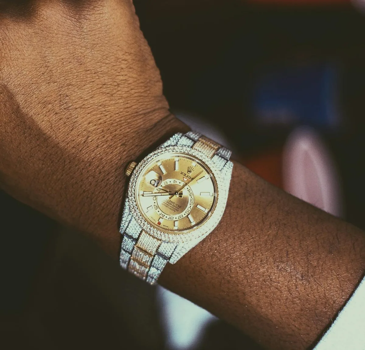 Крупным планом золотые часы с бриллиантовым безелем