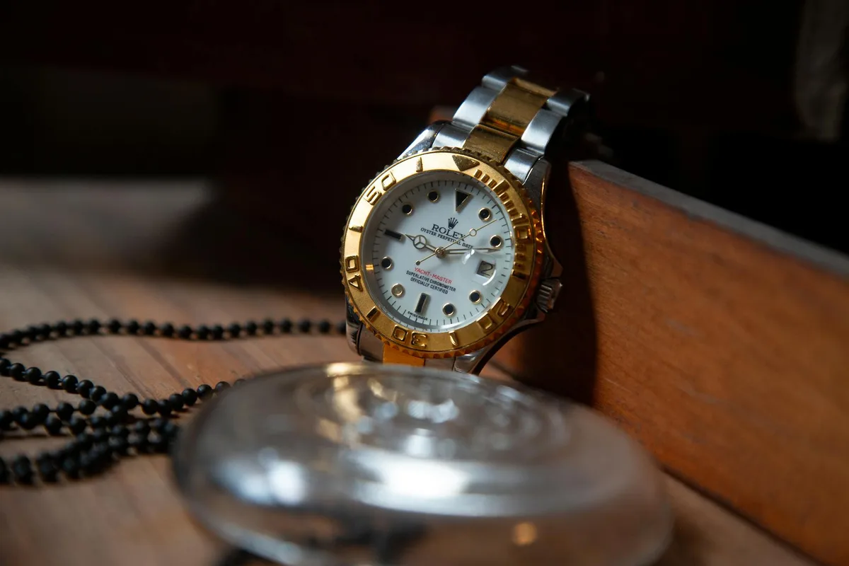 Gros plan d'une montre Rolex de luxe avec détails or et argent, symbolisant élégance et précision.