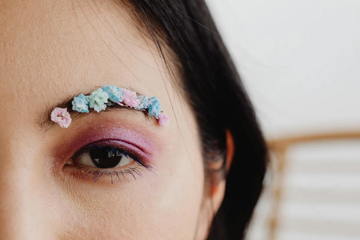 Gros plan d'un sourcil floral artistique avec maquillage vibrant, look créatif