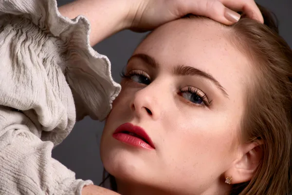 Primo piano di una donna rossa con make-up elegante in interni