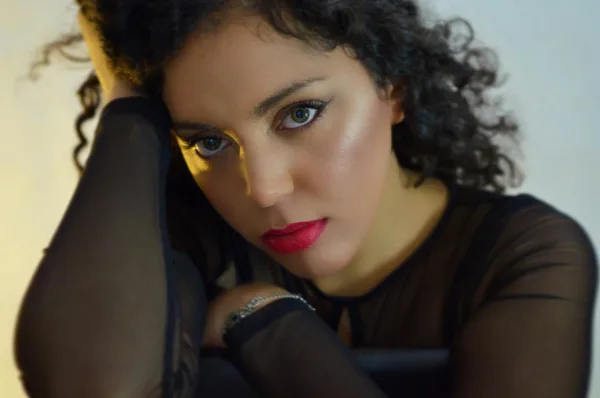 Primo piano di una donna con capelli ricci in mesh nero, eleganza e sicurezza