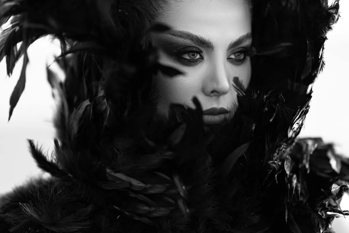 Elegantes Schwarz-Weiß-Porträt einer Frau mit Federn, dramatische Mode