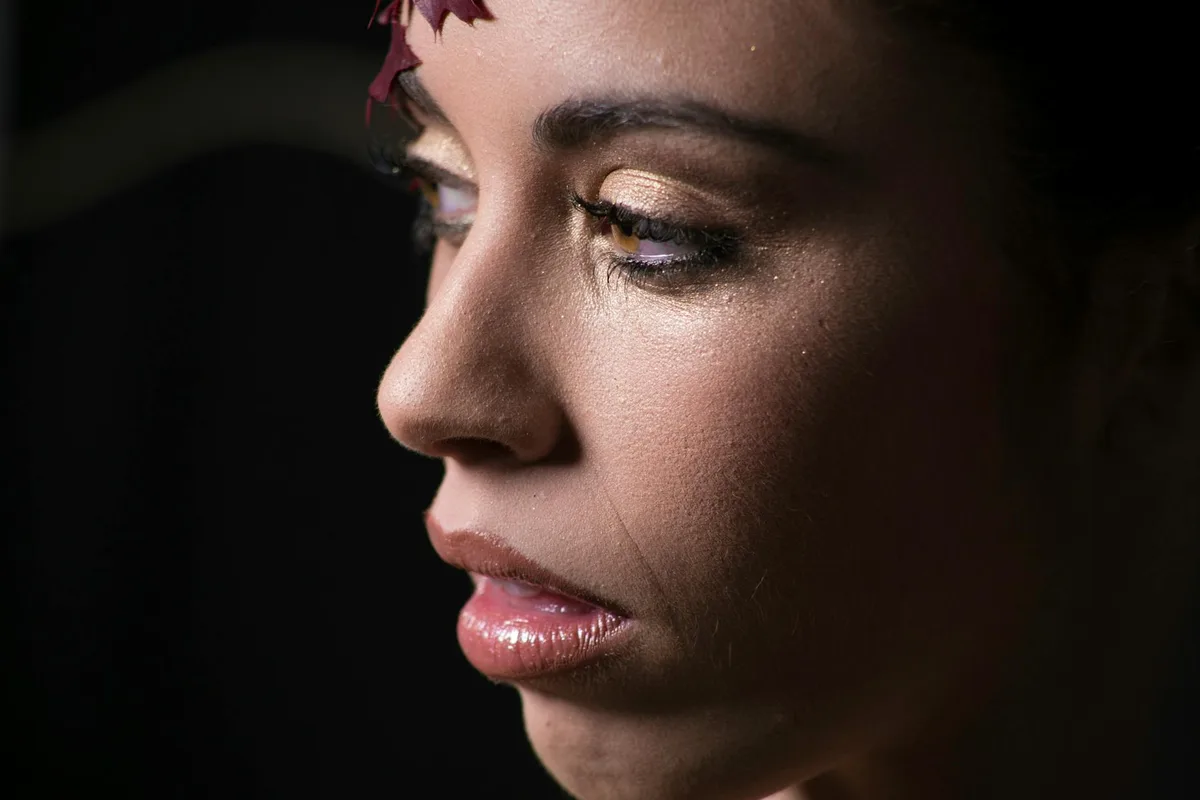 스튜디오에서 글리터 메이크업을 한 여성의 우아한 클로즈업 초상화