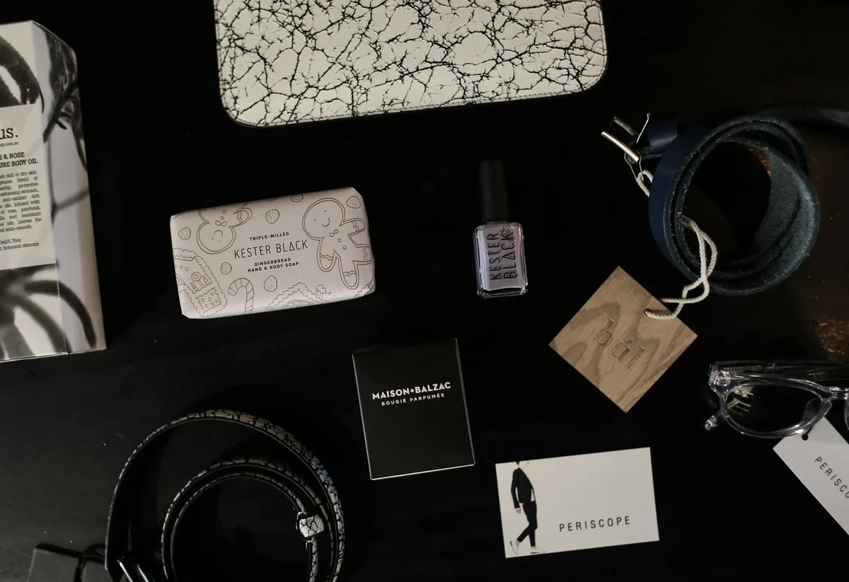 Flatlay élégant avec accessoires, ceinture et parfum sur fond sombre