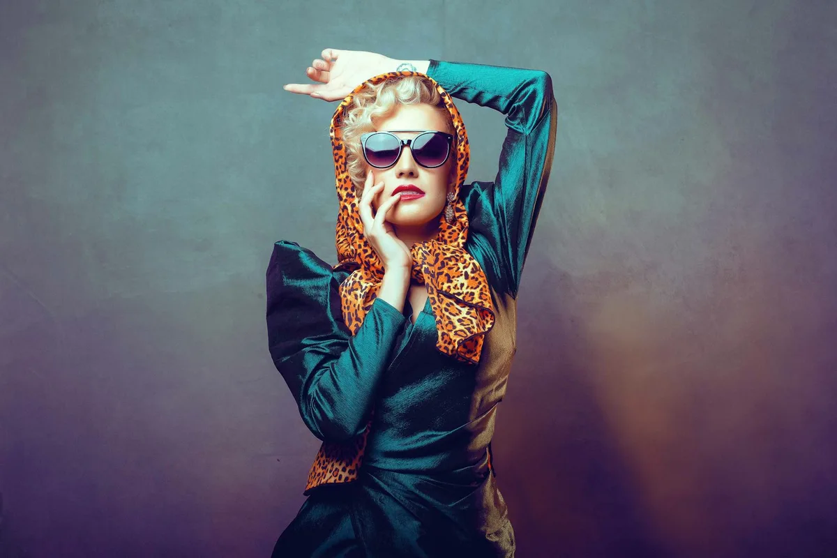 Elegantes Porträt einer Frau in Vintage-Kleidung mit Sonnenbrille und Kopftuch