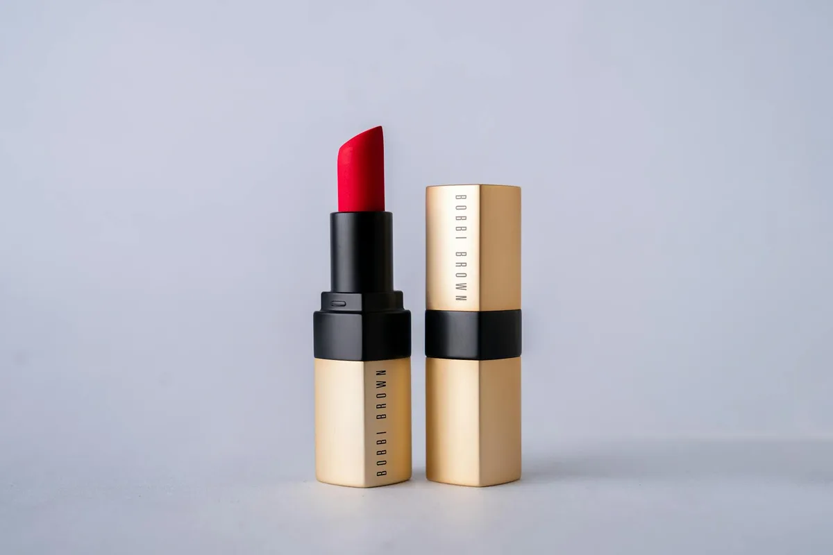 Eleganter roter Bobbi-Brown-Lippenstift vor minimalistischem grauem Hintergrund