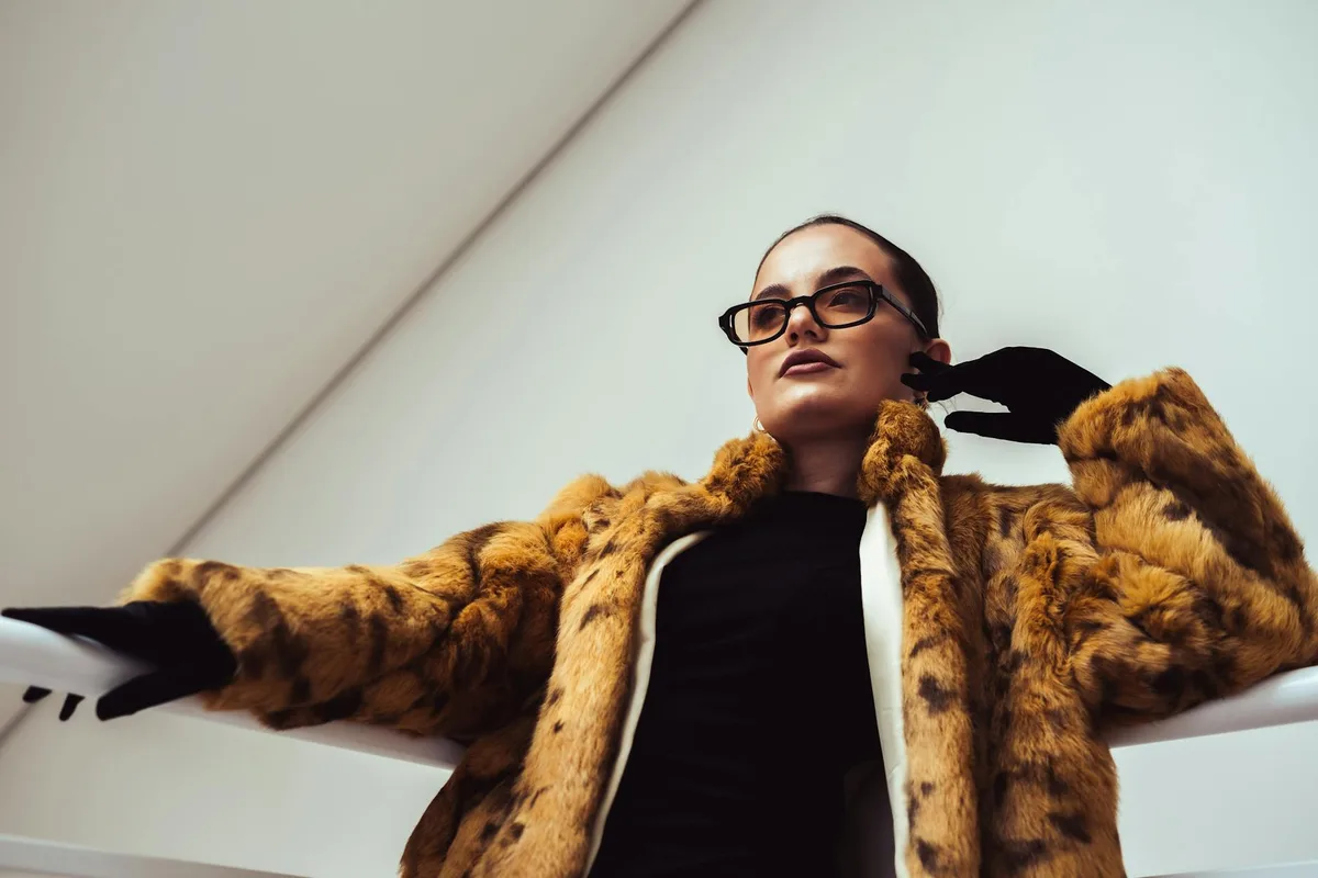 실내에서 모피 코트와 안경 착용하고 우아함 발산하는 패션 여성