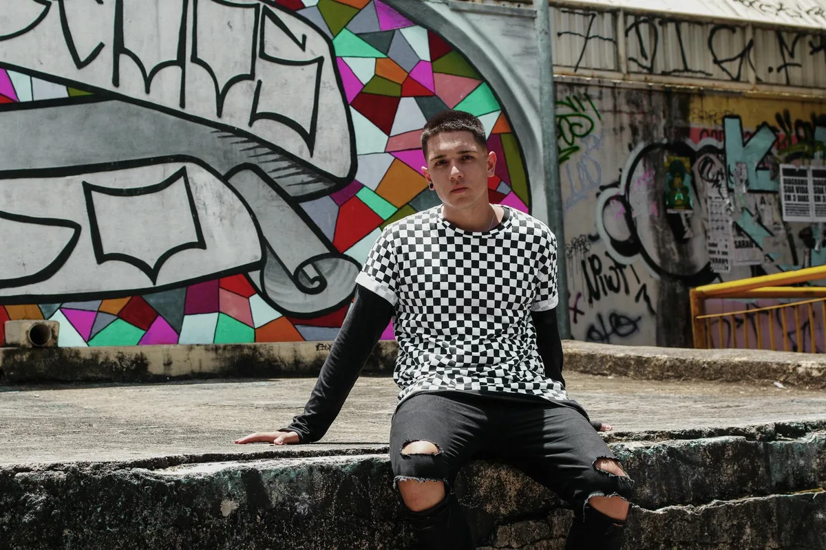 Портрет стильного молодого человека у яркой стены с граффити