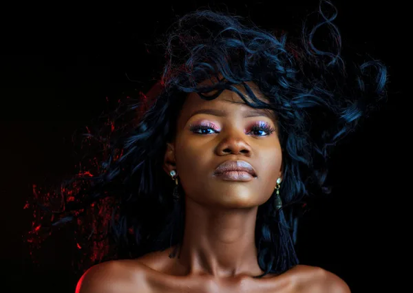 Ritratto sorprendente di donna sicura con illuminazione drammatica e acconciatura