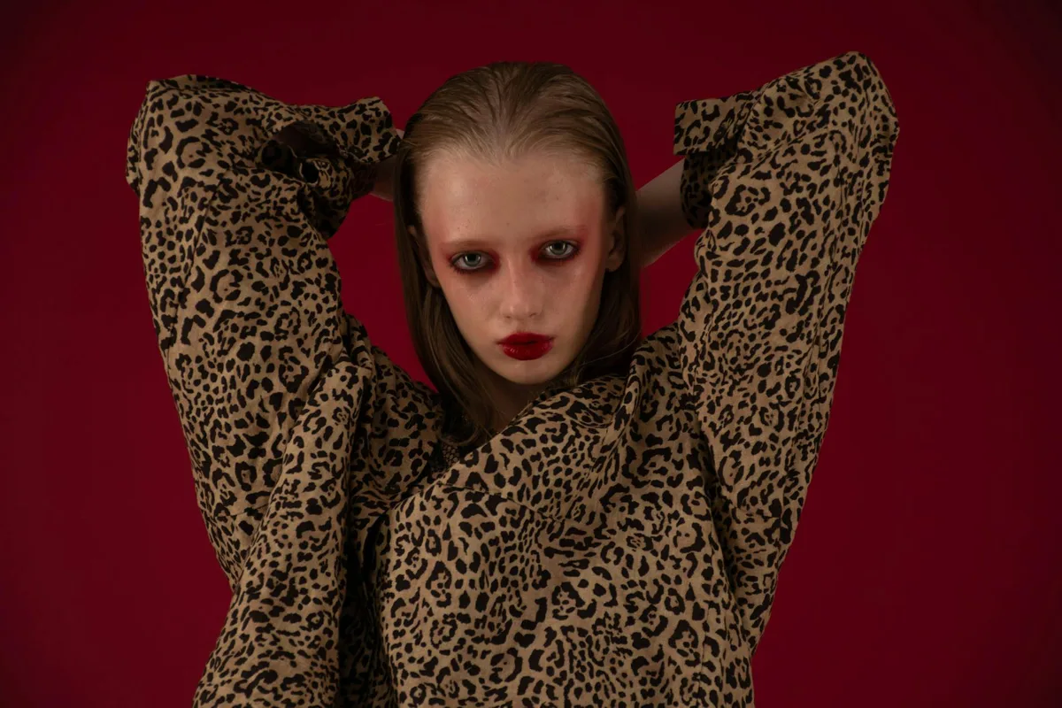 Ritratto sorprendente di modella in stampa leopardo con make-up audace in studio