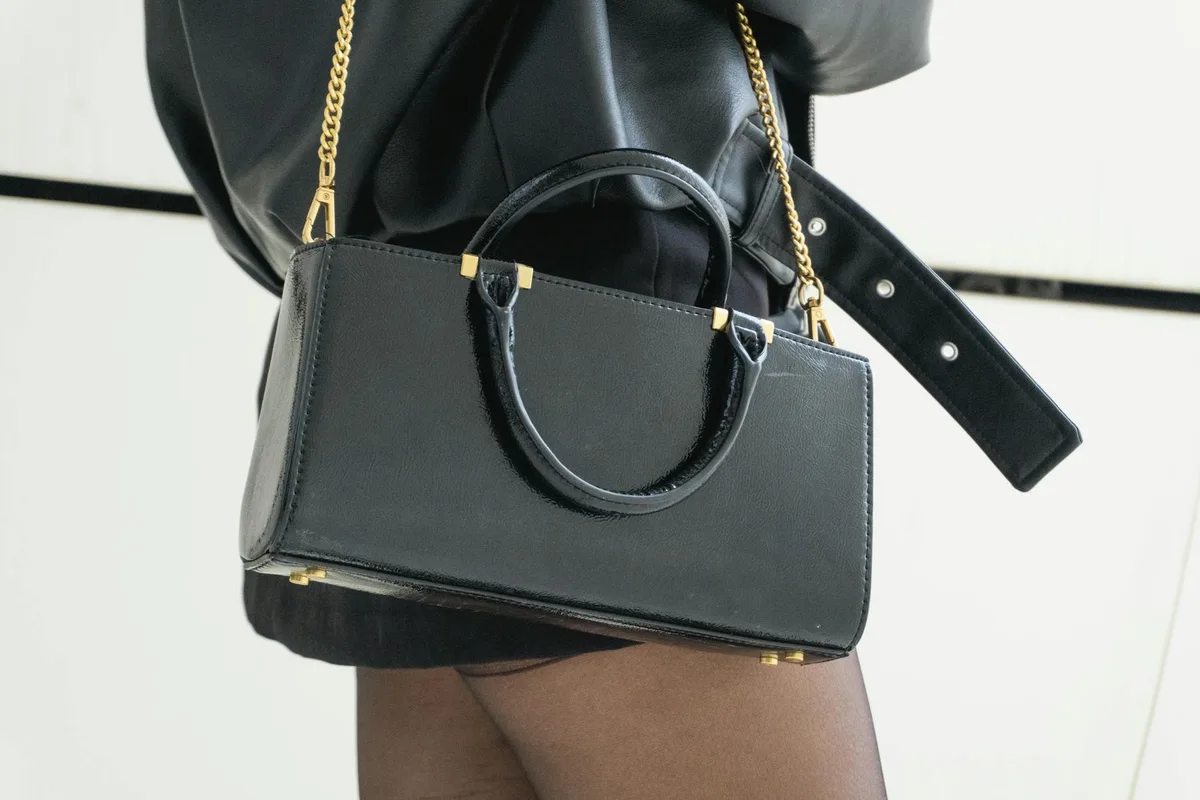 Schwarze Lederhandtasche mit Goldkettenriemen für schicke und moderne Outfits