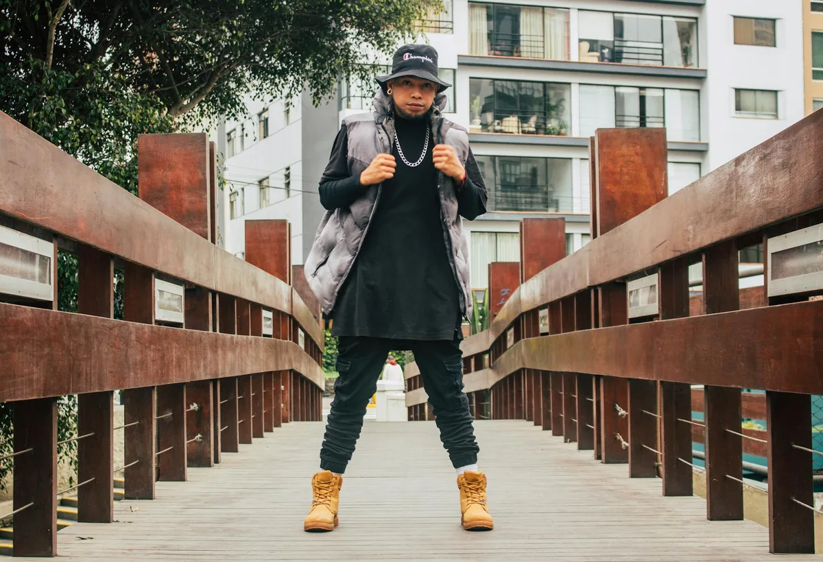 도시 나무 다리 위에서 포즈 취하는 스타일리시한 남성