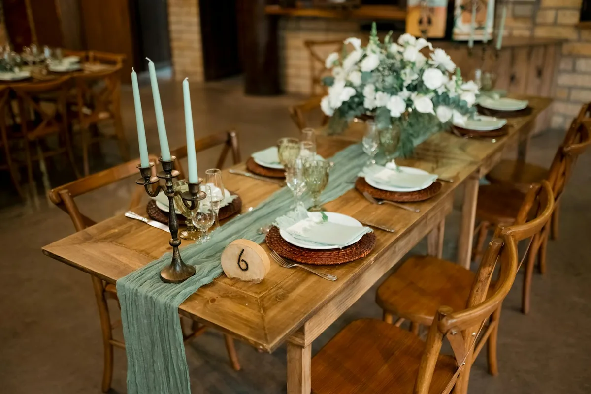 A beautifully arranged rustic table setting with candles and floral centerpiece, ideal for weddings.