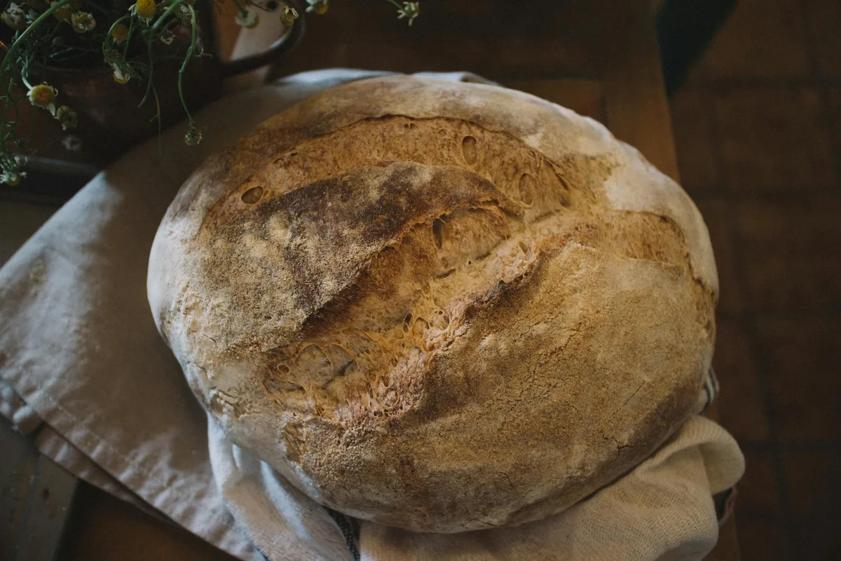 Primo piano di pane a lievitazione naturale rustico fatto in casa, consistenza e crosta in evidenza