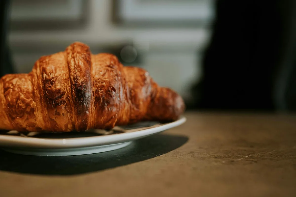 金黄可颂面包，陶瓷盘盛装，完美早餐搭配