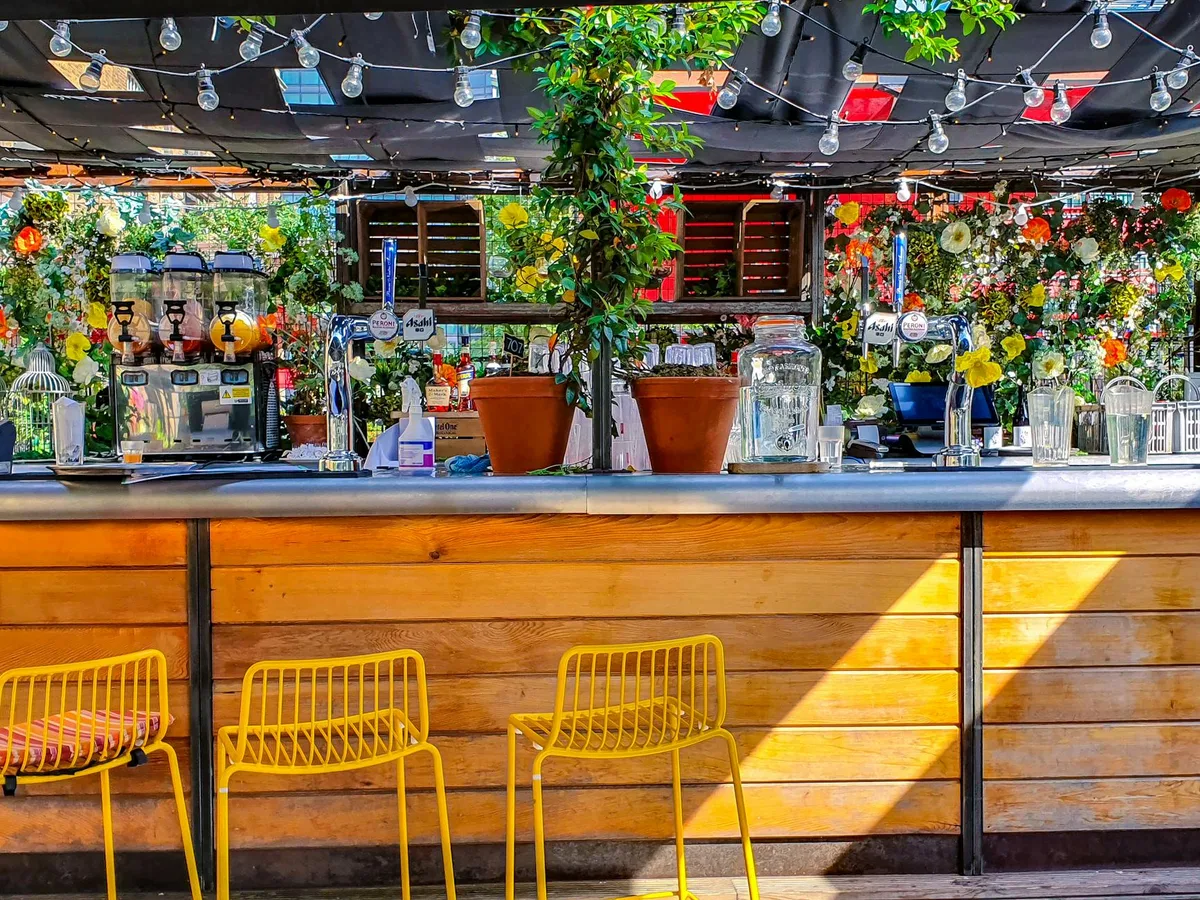 Scène de bar extérieur animé à Londres, fleurs et décor colorés
