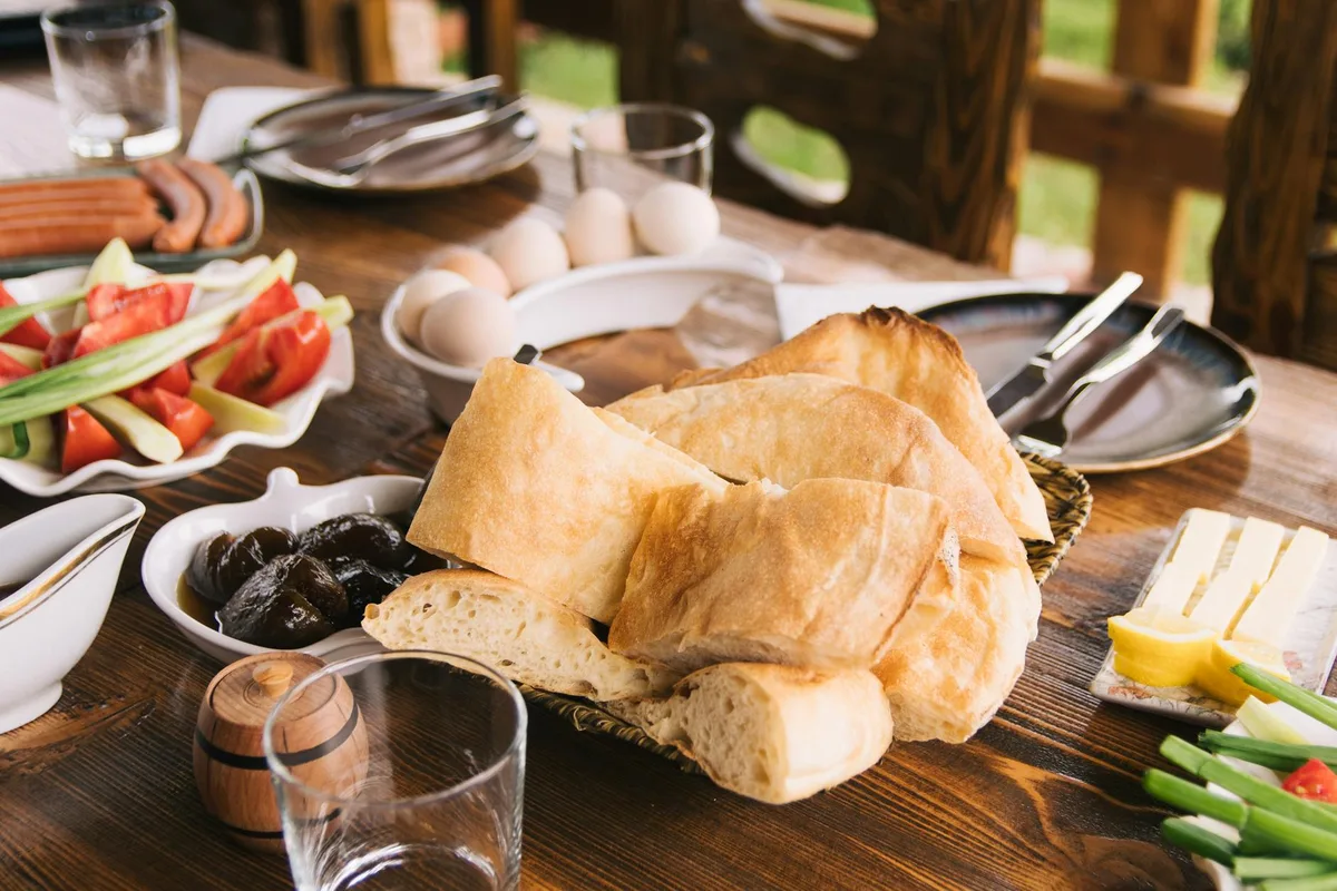 Rustikaler Holztisch mit frischem Brot und Gemüse für ein gesundes Frühstück