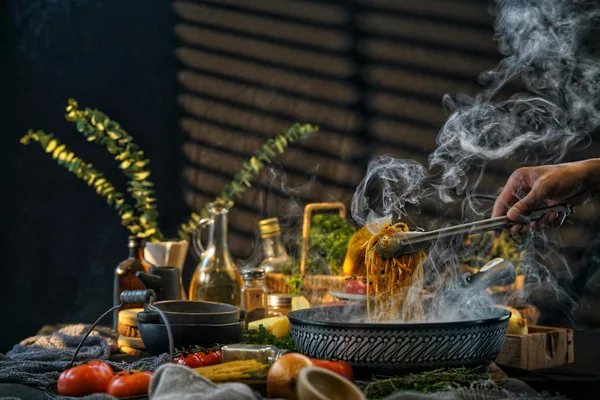 Ciotola fumante di pasta servita in una cucina rustica con ingredienti freschi e utensili