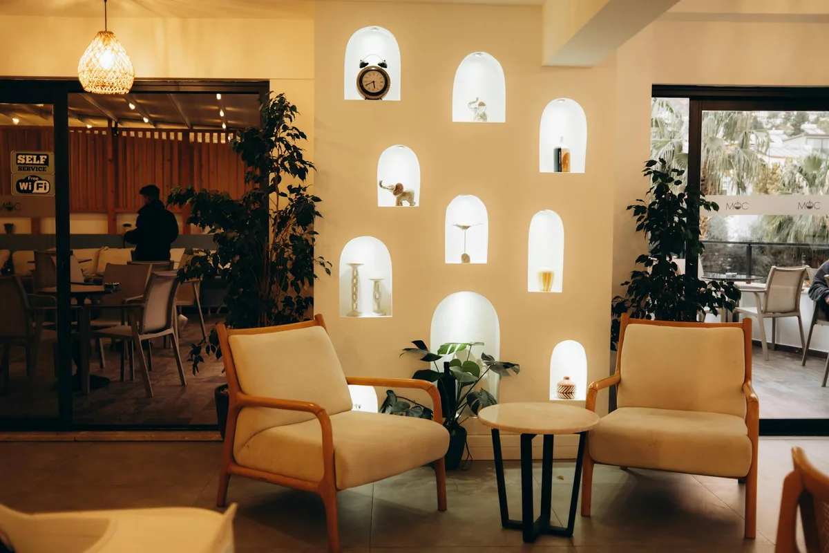 Stilvolles Innenraum-Café mit moderner Einrichtung, bequemen Sitzgelegenheiten und beleuchteten Nischen